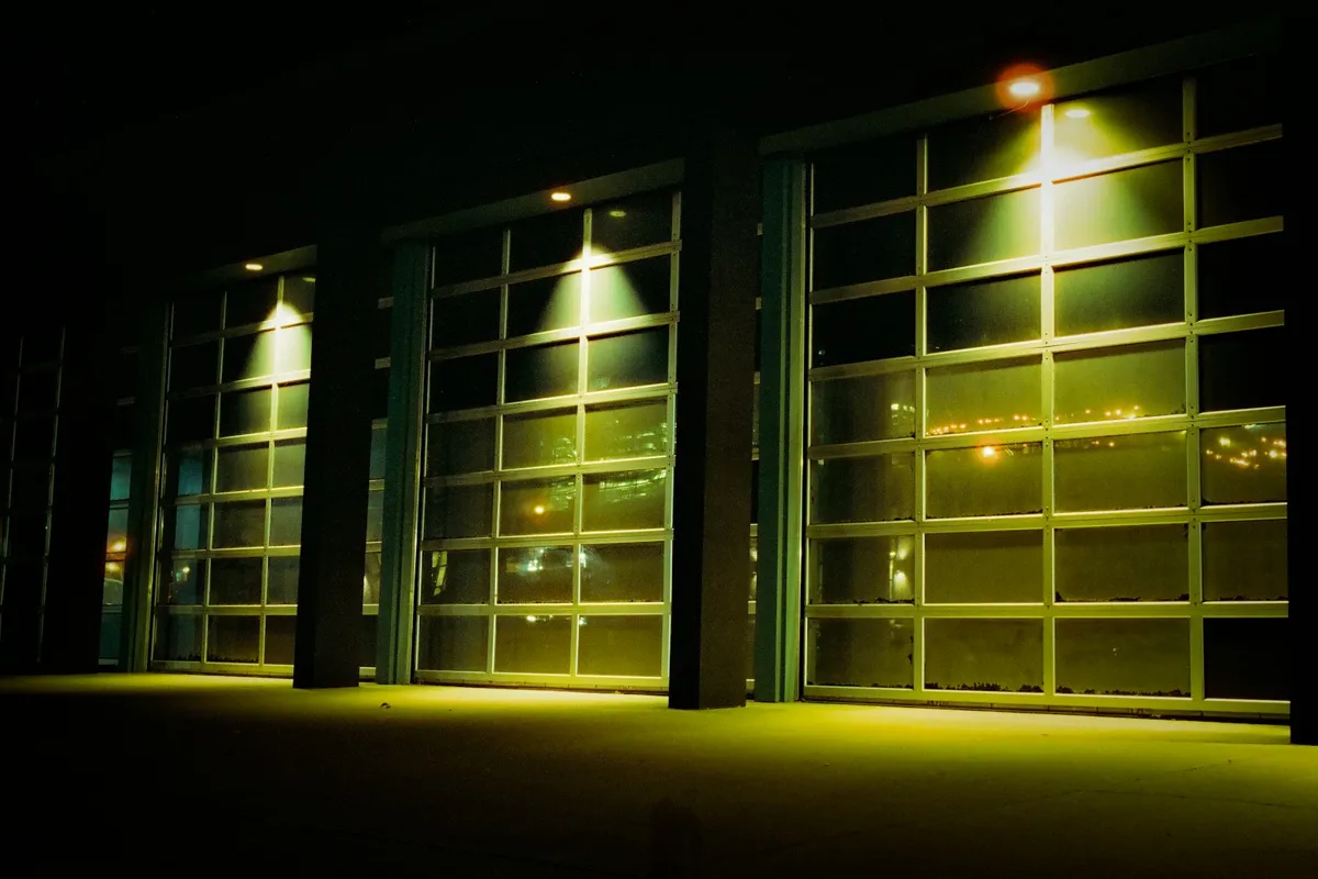 Three full-view glass doors lit from inside at night